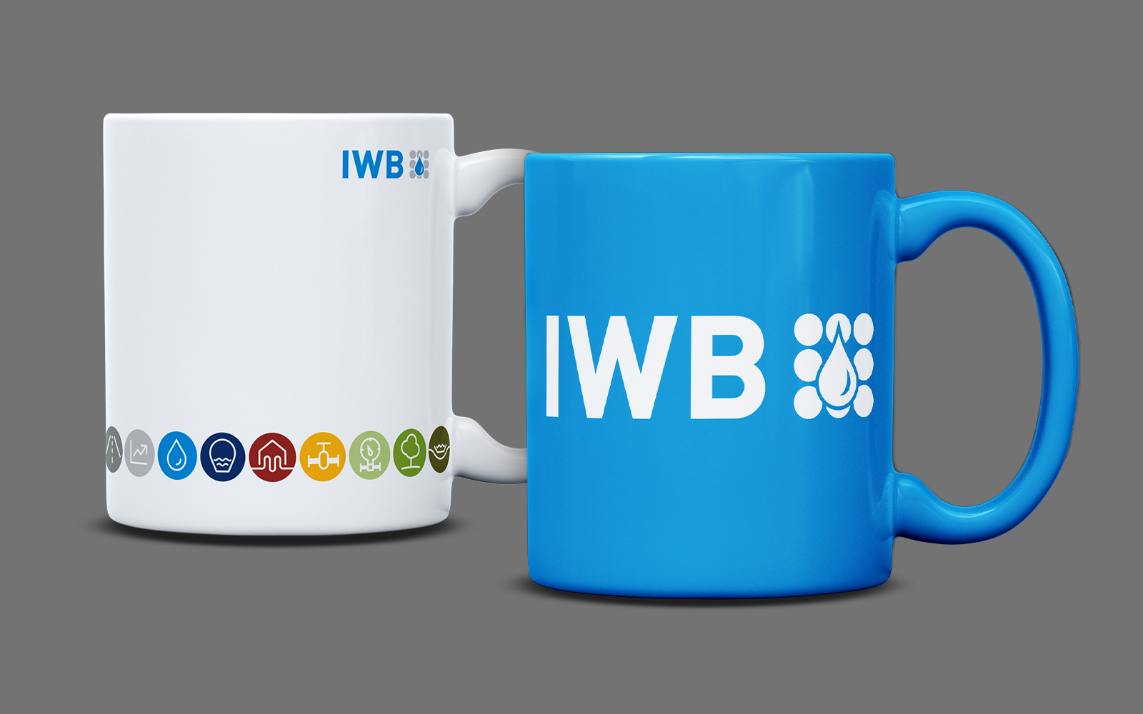 eine weiße und eine blaue Tasse mit IWB-Logo