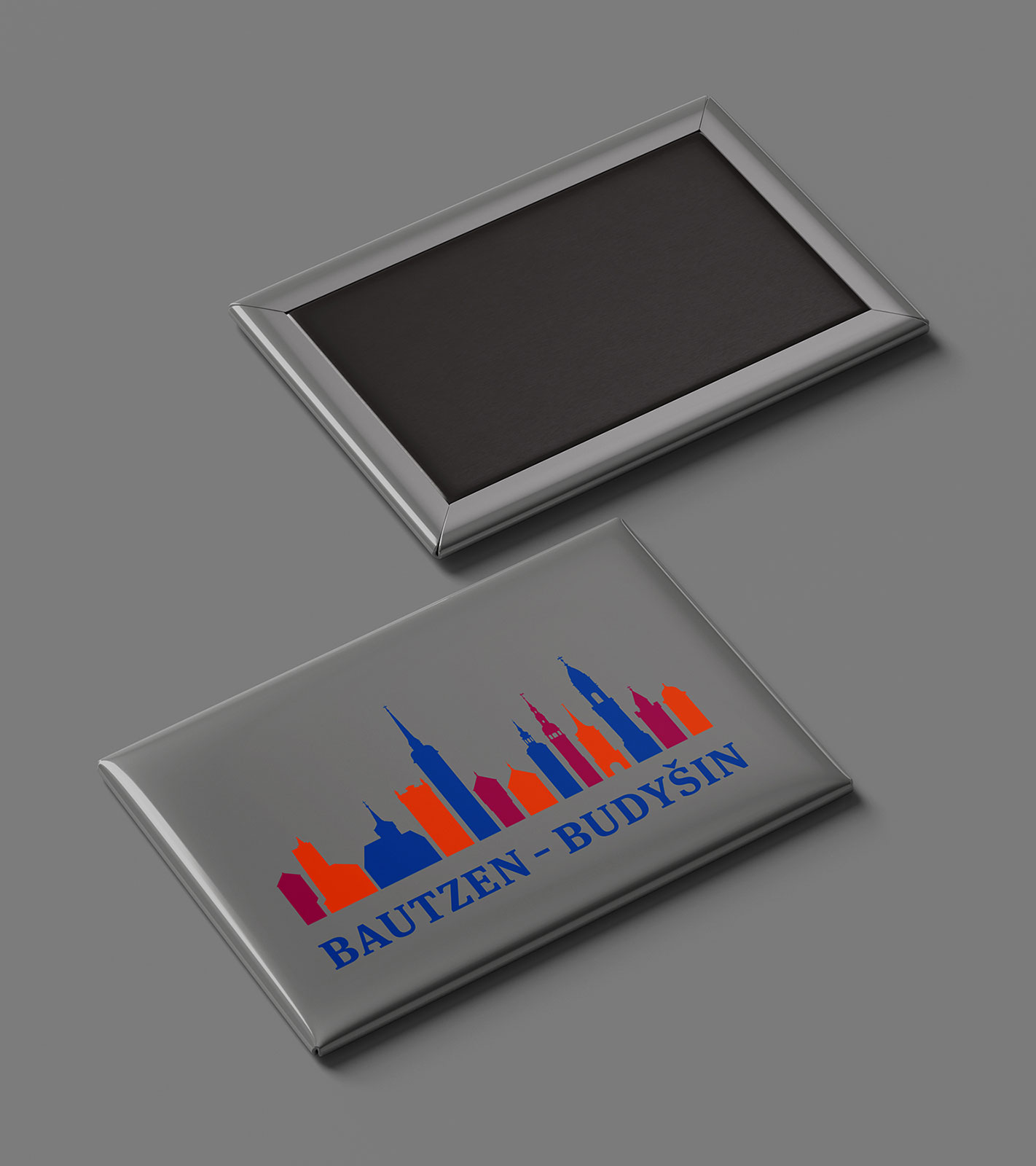 rechteckiger grauer Magnet mit farbiger Türme-Silhouette und Bautzen-Schriftzug, zweiter Magnet zeigt Rückseite